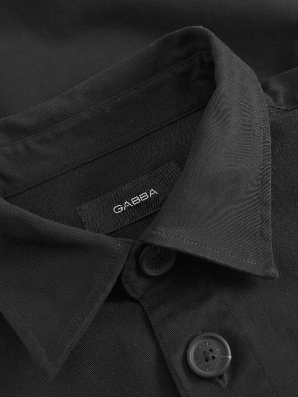 Close-up of the GABBA GABtopper LS Shirt in black, showing its shirt collar, black buttons, and visible inner GABBA label.