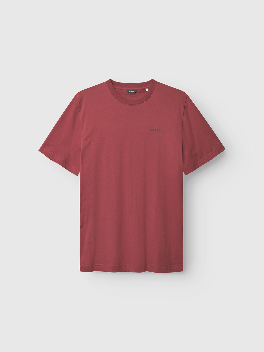 The Gabba GABdune Logo GOTS SS T-Shirt in Red Russet features a classic fit, crew neckline, and short sleeves. Made from organic cotton, it’s shown against a light gray background.