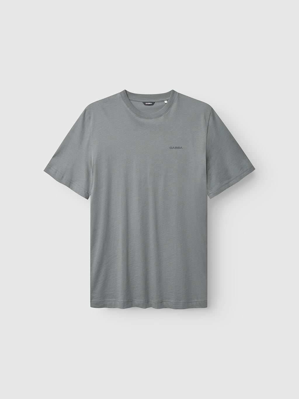 The Gabba GABdune Logo GOTS SS T-Shirt in Dust Sage Green, featuring a classic fit, short sleeves, round neckline, and a small logo on the left chest, is displayed against a light gray background.