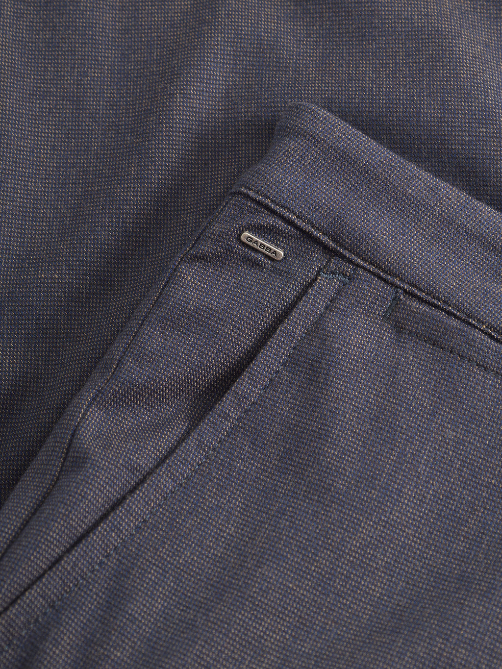 Close-up of Gabba's Paul Domo slim chino pant in dark navy melange, featuring textured fabric, French pockets, and a small metallic 