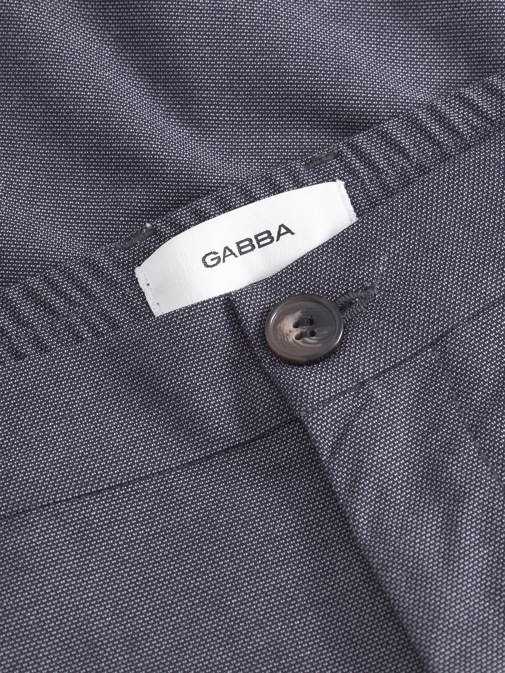 Close-up of Monza Button Carre - Navy trousers by Gabba, featuring dark navy textured fabric, a button, relaxed straight fit, and a white Gabba label stitched on the waistband for versatile style.