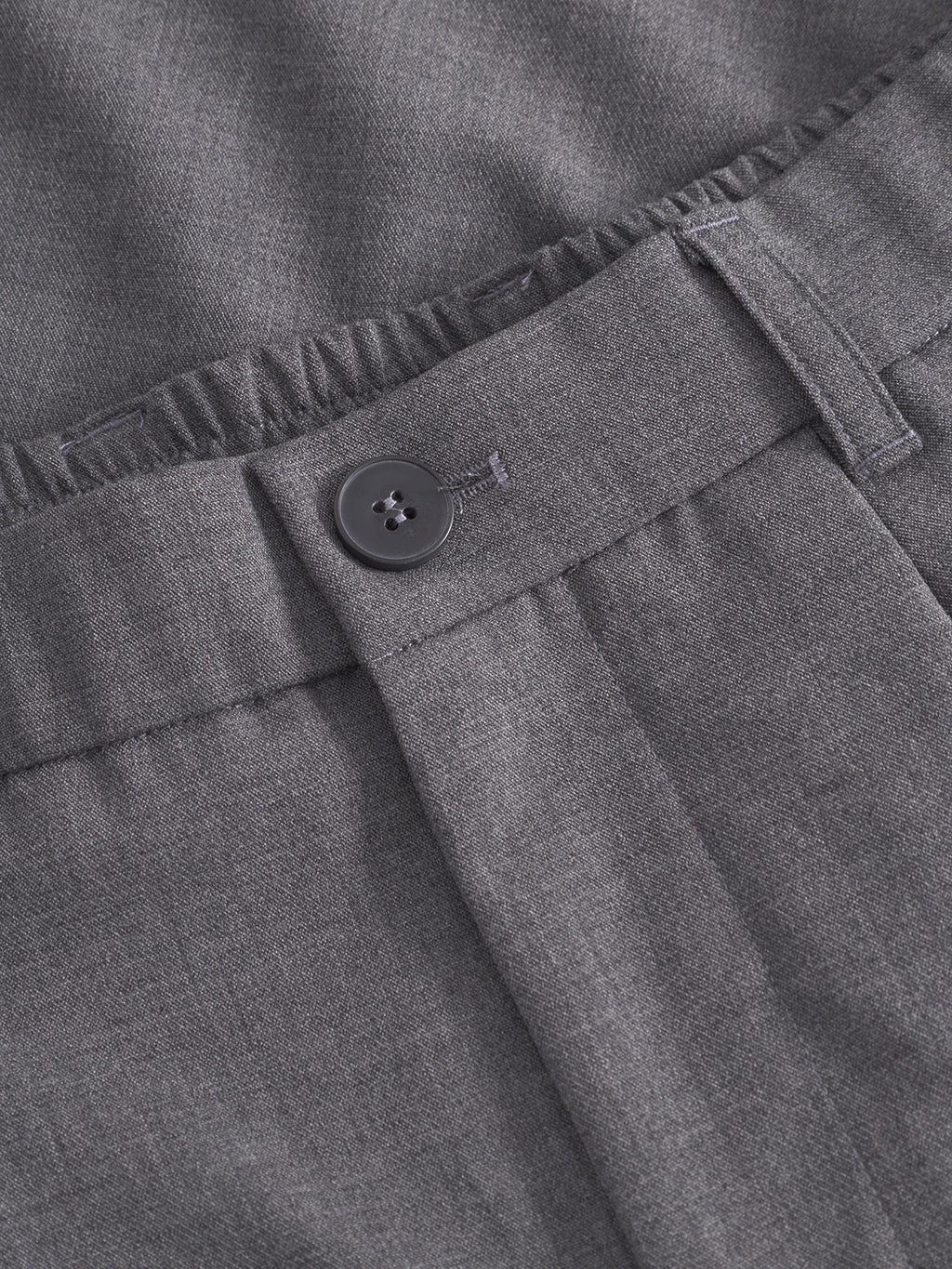 Close-up of the Gabba GABnapoli 19 Phin GRS - Dk. Grey dress pants, showcasing an elastic waistband, belt loops, and a single black button above the zipper. Crafted from a soft wool blend chino with a smooth, subtly textured finish, these pants offer a regular straight fit that combines timeless style with everyday comfort.