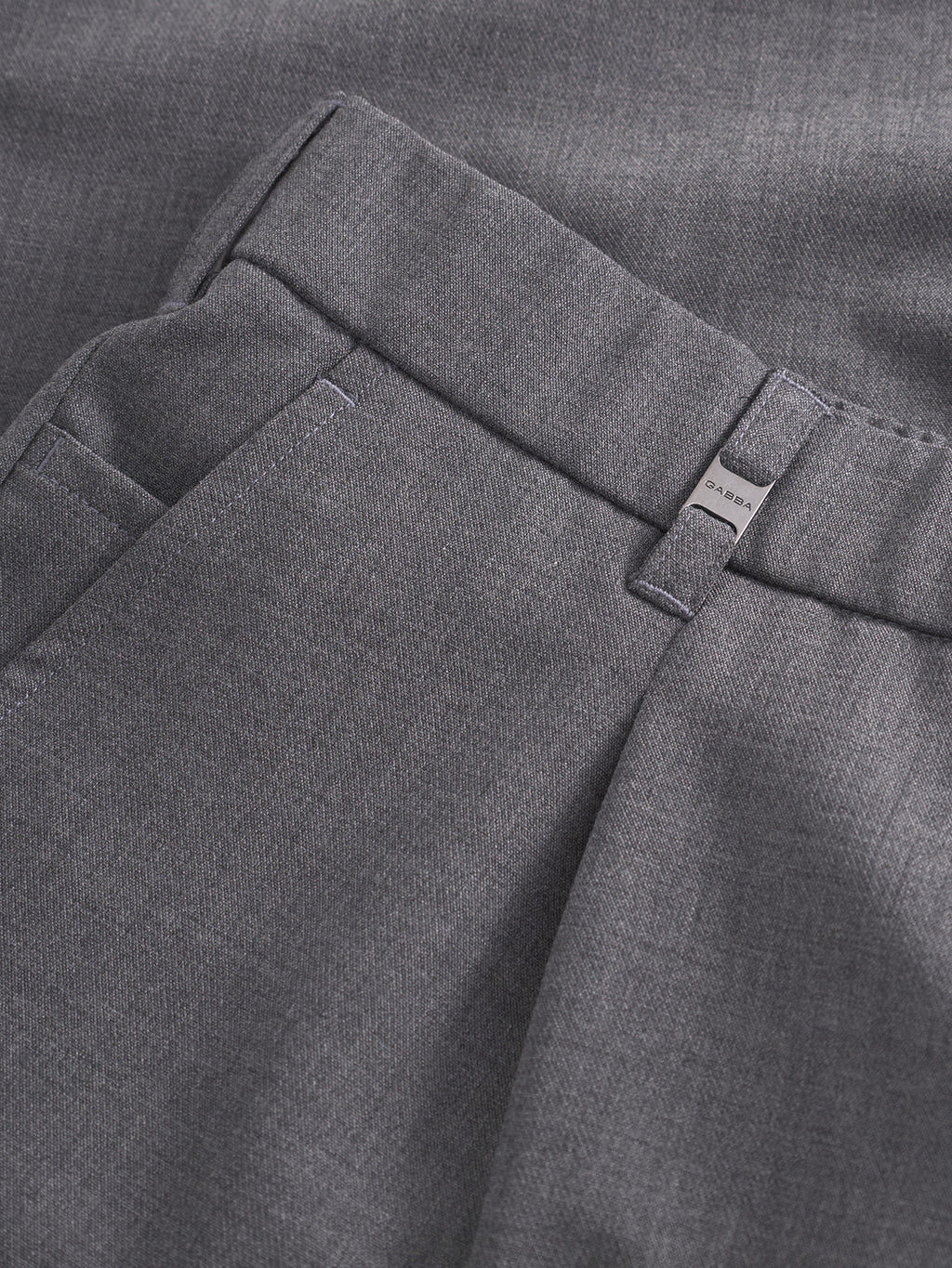 Close-up of the Gabba GABnapoli 19 Phin GRS dress pants in dark grey, highlighting the waistband, belt loop, and partial view of a pocket. Made from a wool blend chino fabric with recycled polyester, these pants showcase a fine, smooth texture and offer a regular straight fit.