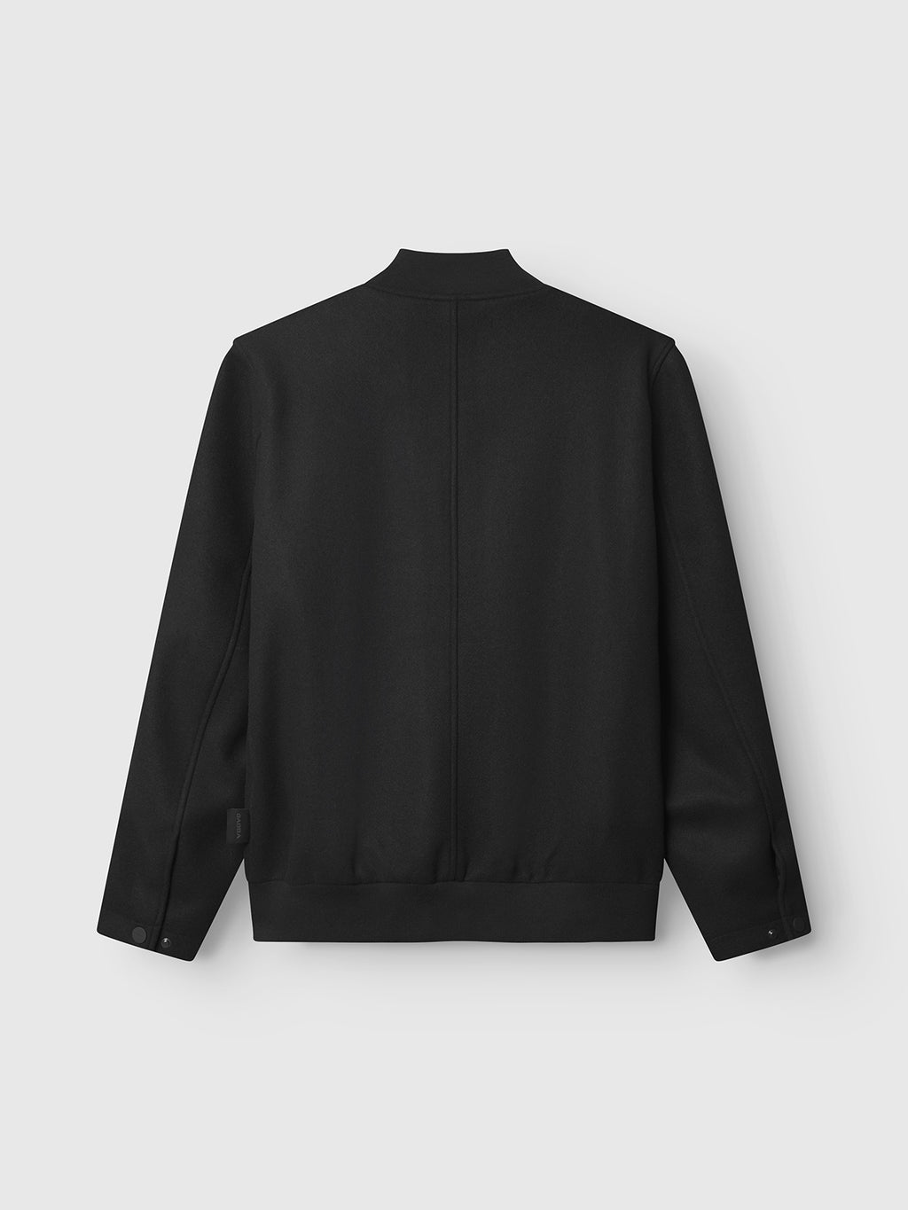 The Orta Wox - Black bomber jacket by Gabba is displayed from the back on a light gray background, featuring long sleeves, a straight hem, and a simple collar in a breathable, unbranded design.