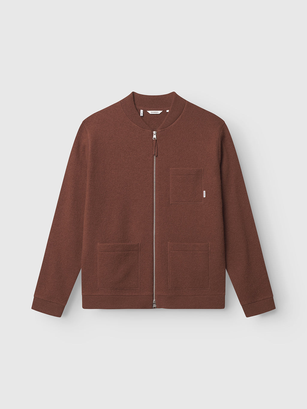 The Cardiff Led - Brownish by Gabba is a brown wool bomber jacket with a round collar, long sleeves, and three front pockets. Made from boiled wool, it features modern tailoring set against a plain light gray background.