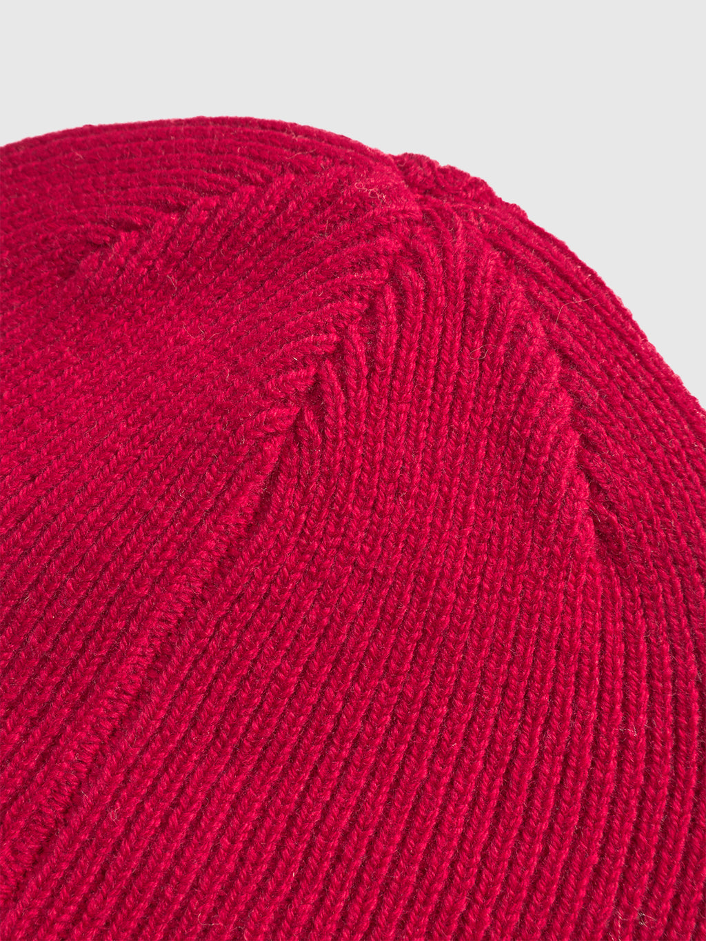 Close-up of the Biella Aico - Red beanie by Gabba, highlighting its vivid ribbed knit texture and stitching, set against a light background.