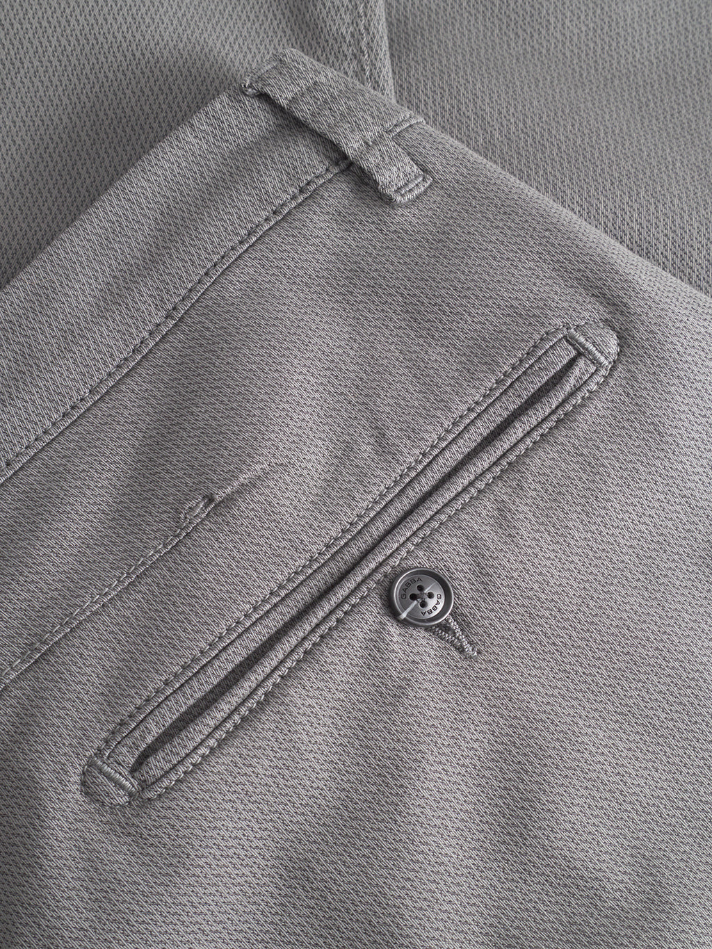 Close-up of Gabba GABpaul K3280 Dale Chino in Dust Sage Green, showing detailed stitching, buttoned slit back pocket, French pockets, textured fabric, and slim leg opening.