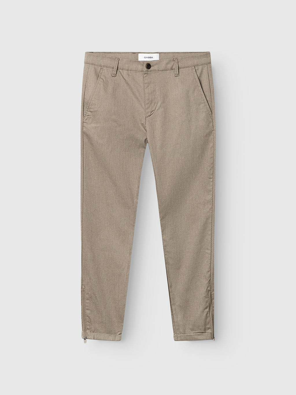 The Pisa K3280 Dale Pants - Humus by GABBA are a pair of light brown slim tapered fit pants crafted from a high-stretch cotton-blend fabric. They feature side pockets, a button and zip closure, and the brand’s signature zip detail at the ankles, shown against a plain white background.