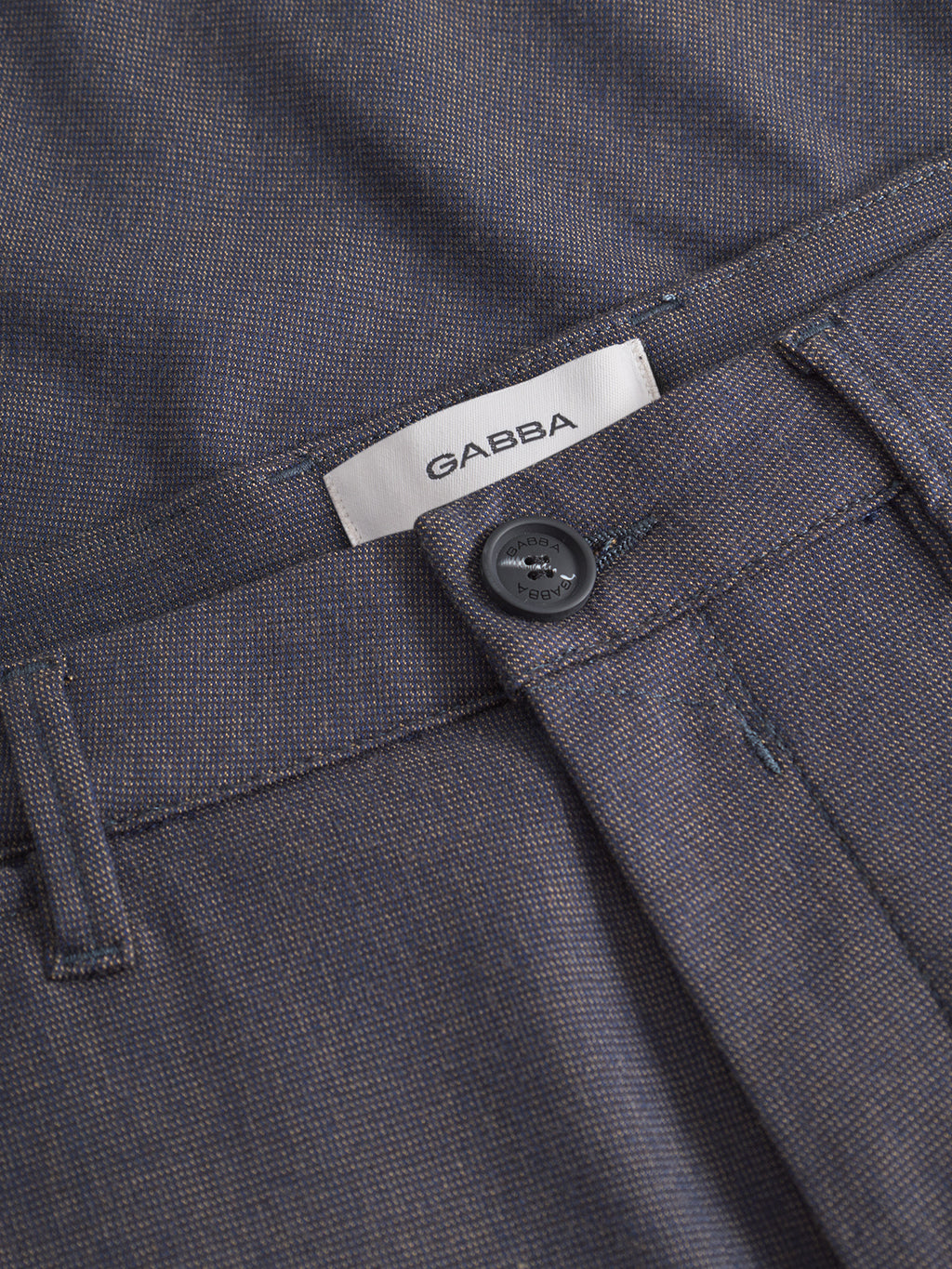 Close-up of the waistband of Paul Domo - Dark Navy Melange slim chino pants by Gabba, featuring branded buttons, belt loops, and French pockets. A white Gabba label is visible on the inside of the waistband.