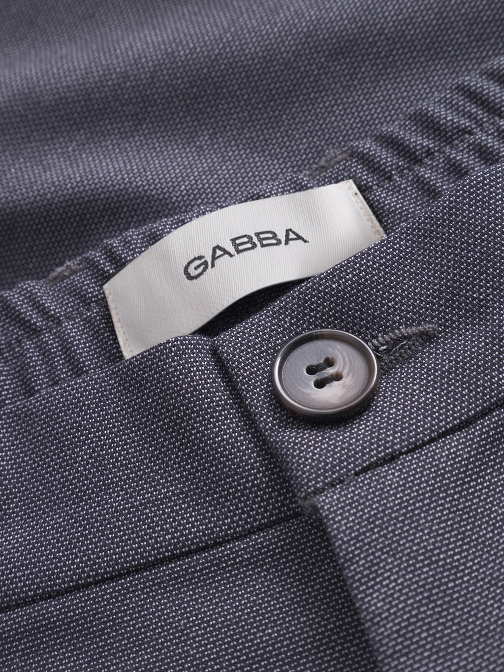 Close-up of navy textured fabric trousers in classic style, showing a button, buttonhole, and a white Gabba label stitched inside the waistband—these are the Napoli 19 Carre - Navy pants designed for comfort.