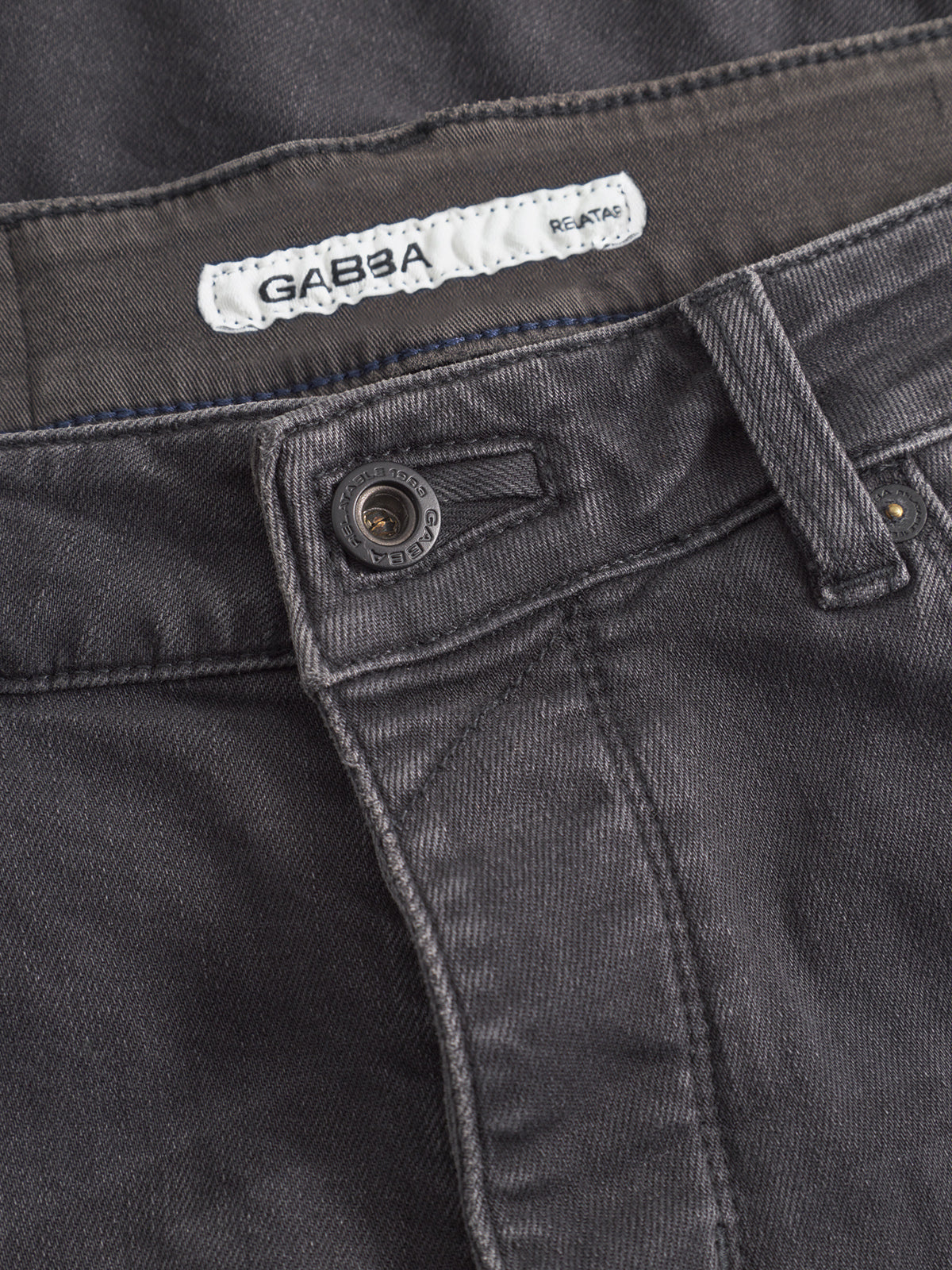 Close-up of the waistband and zipper of GABBA's GABrey Thor Jeans in denim wash, with a metal button, belt loops, and an inside white GABBA label—ideal for a laid-back look.