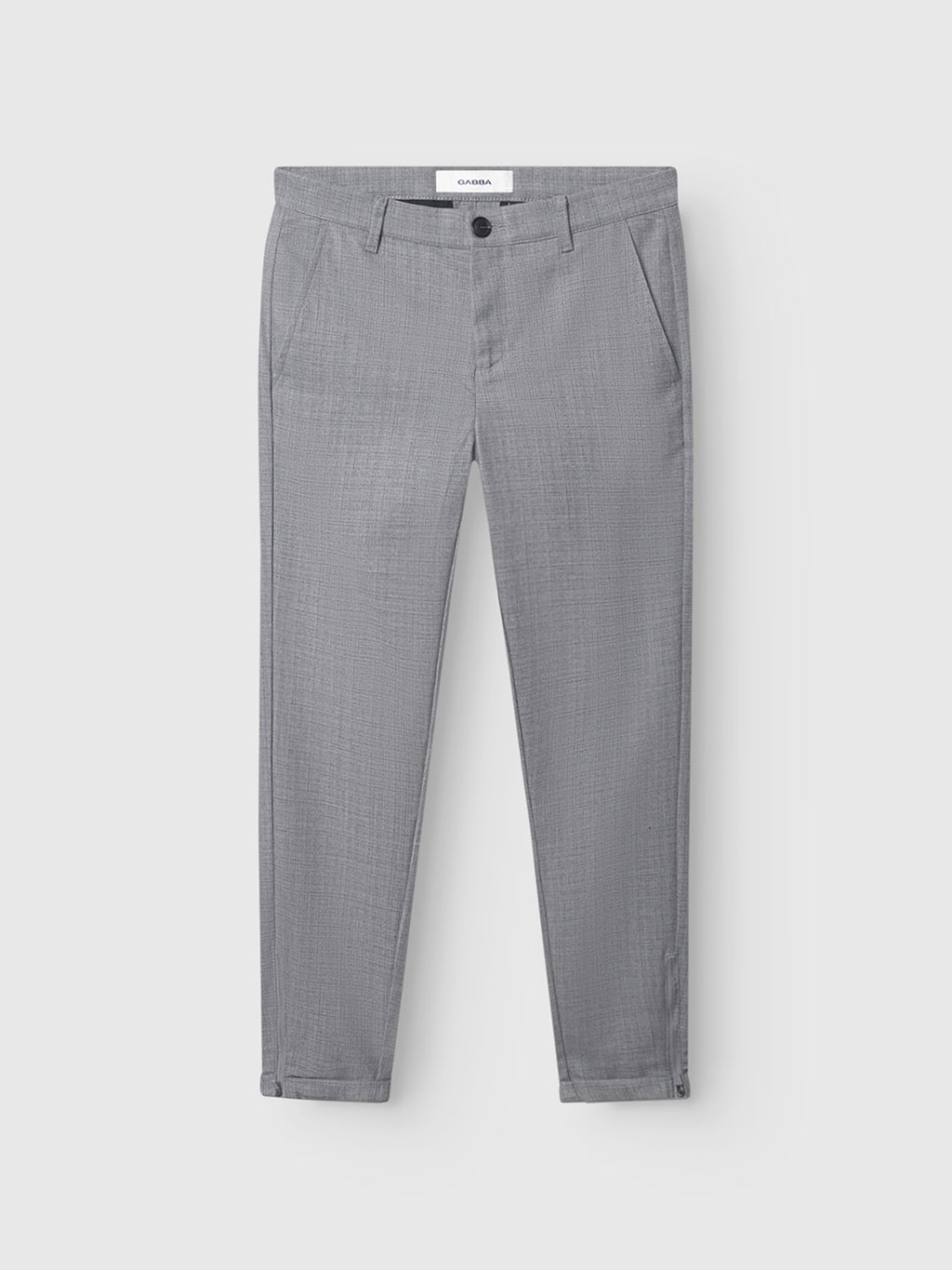 The Pisa Cross Lt Grey pants by GABBA feature a slim tapered fit in light grey, crafted from high-stretch cotton-blend fabric. Designed with front and back pockets, belt loops, a button closure, and the brand’s signature zip detail, these pants are showcased against a plain light background.
