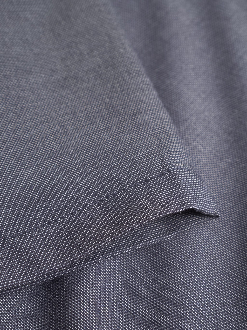 Close-up of the Monza Button Carre - Navy by Gabba, showcasing dark gray textured fabric with fine weave and visible stitching—ideal for relaxed straight pants, clean seams, and a smooth surface for versatile style.