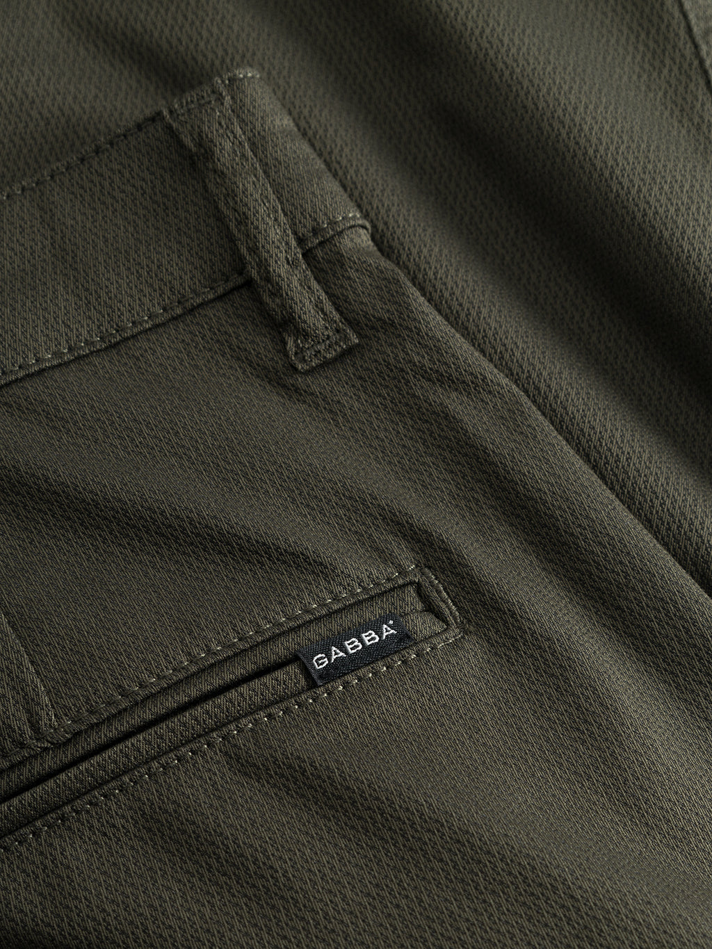 Close-up of an olive green fabric pocket on GABBA Pisa Cargo K3280 Dale Pants - Army, featuring a slim tapered fit, black GABBA label by the zipper, and super stretch fabric for a modern city style.