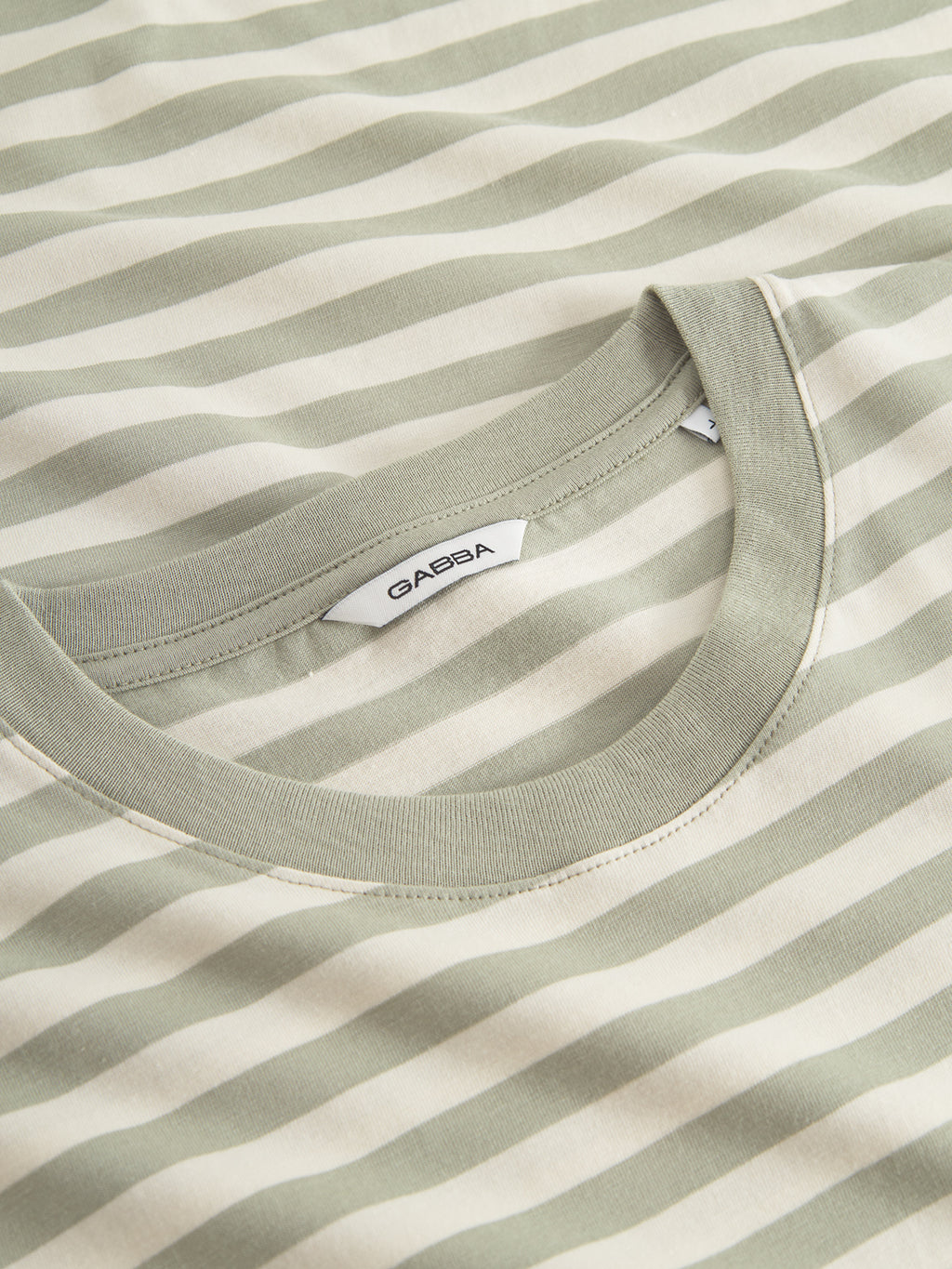 Close-up of the Gabba GABdune Logo Stripes SS GOTS t-shirt in green stripe, made from organic cotton with a round neckline. Features a branded inside label.