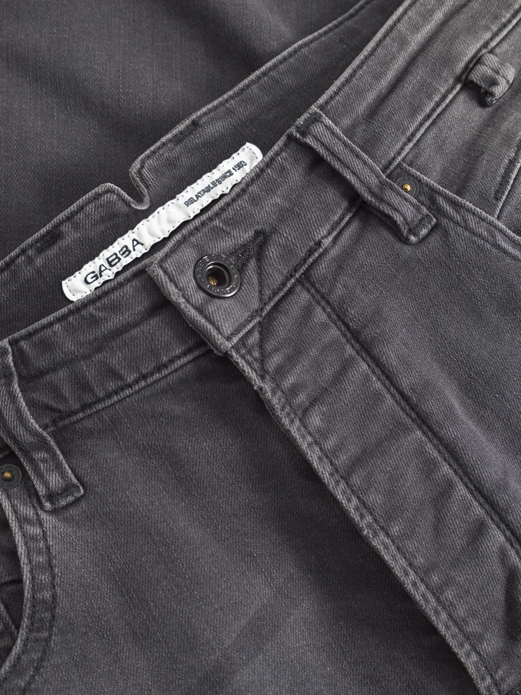 Close-up of GABBA GABalex Thor Cropped Jeans in a denim wash, featuring a visible waistband with worker cut waistbands, belt loops, metal button, and an inner label that reads GABBA.