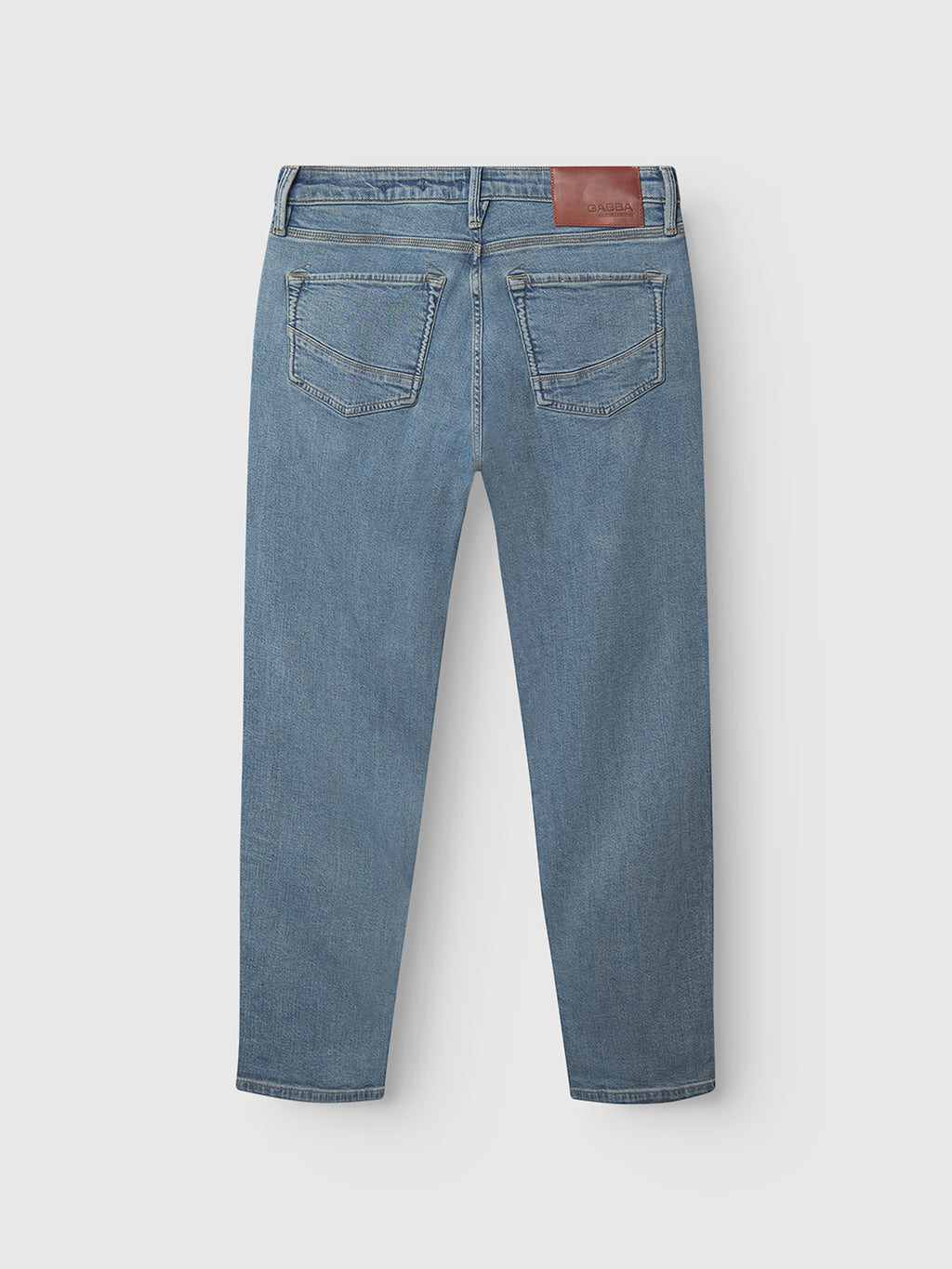 The Gabba GABmax Cros Lt. Blue Denim jeans feature a modern slim fit, two rear pockets, visible stitching, and a brown leather patch on the waistband, shown here from the back.