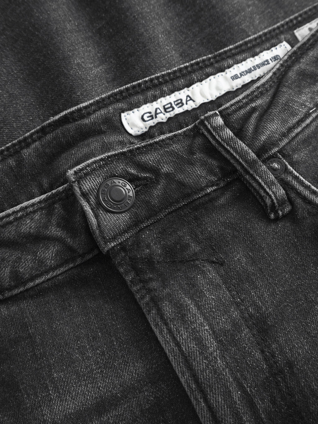 Close-up of the GABmax F1011 - Black Denim waistband, featuring a metal button, belt loops, and a white inner Gabba label—designed in a slim fit for modern appeal.