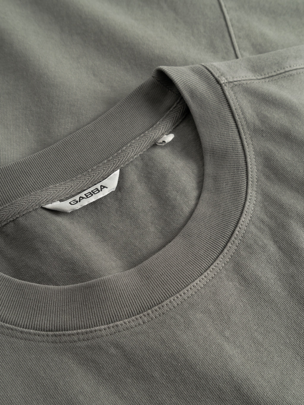 Close-up of two overlapping Gabba GABnigel Wix Boxy Hour SS crewneck t-shirts in Castor Gray, made from heavyweight cotton with smooth, neat stitching and a visible white 