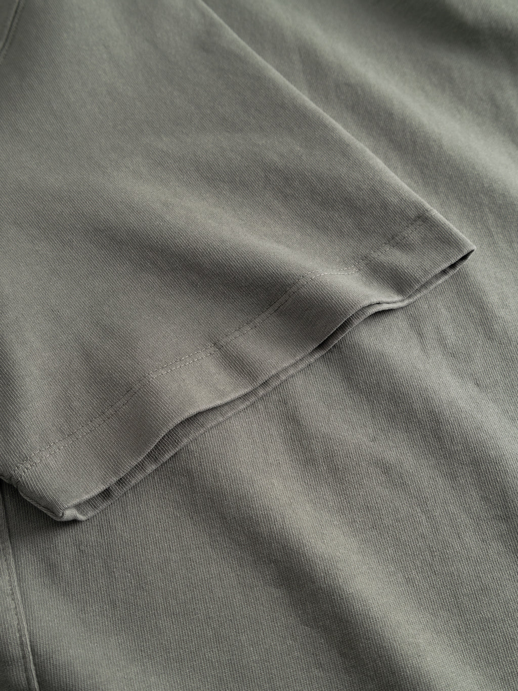Close-up of the Gabba GABnigel Wix Boxy Hour SS in Castor Gray, highlighting its heavyweight cotton fabric, visible stitching, and boxy silhouette with the sleeve laying flat over the shirt.