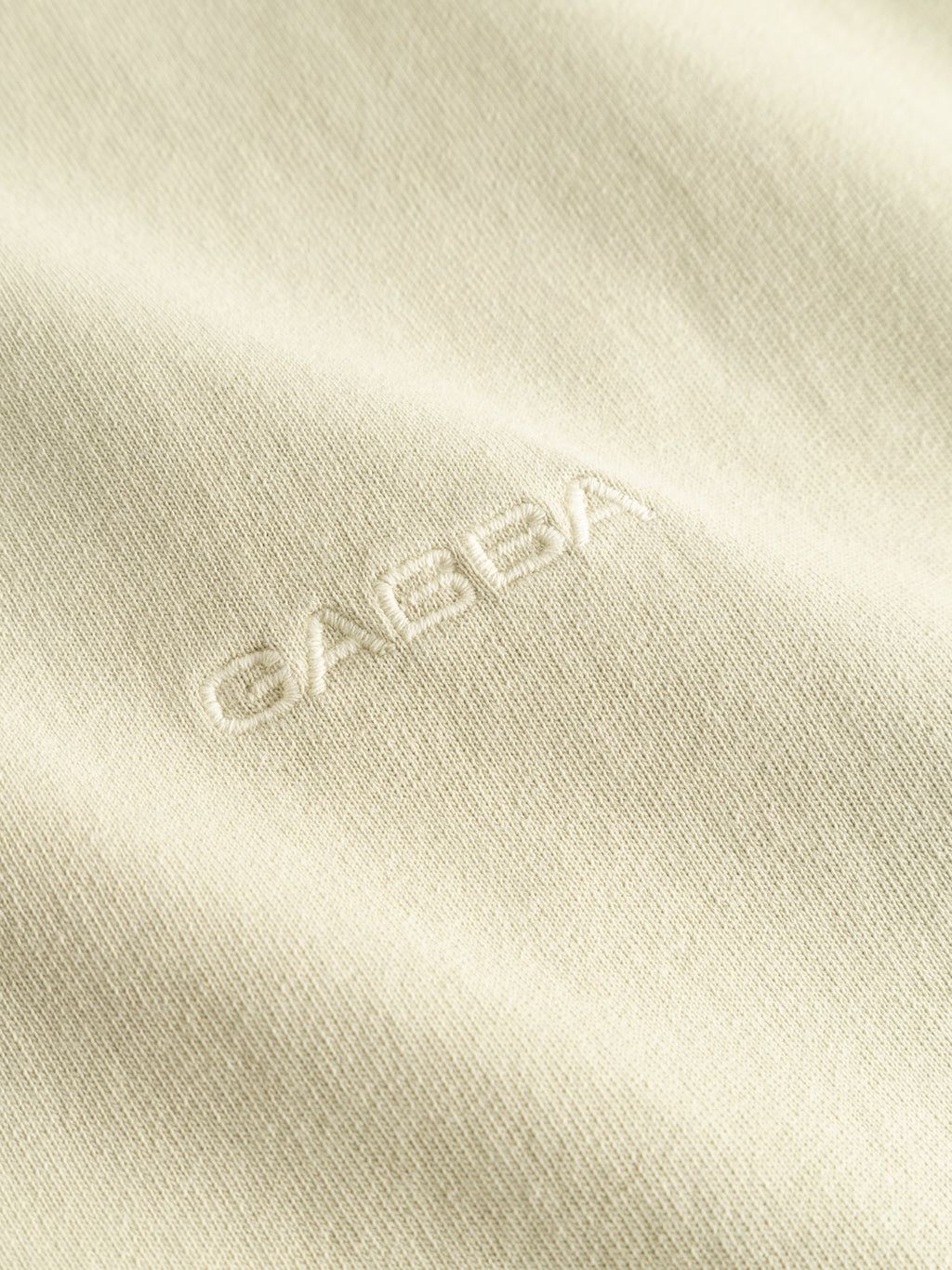Close-up of heavyweight cotton fabric on the GABnigel Wix Boxy Hour SS - Alfa Green t-shirt by Gabba, featuring a subtle textured 'GABBA' logo embroidered in matching thread.