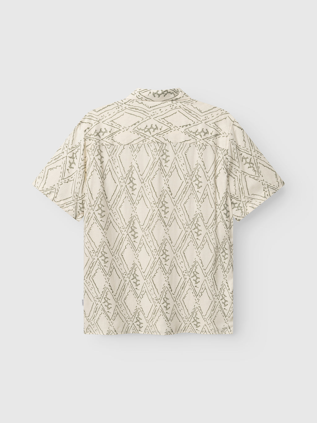 The Gabba GABsven Reg Zag SS Shirt features soft TENCEL cotton, a cream base, and multipattern geometric diamonds and zigzags in light gray. Shown from the back against a white background.