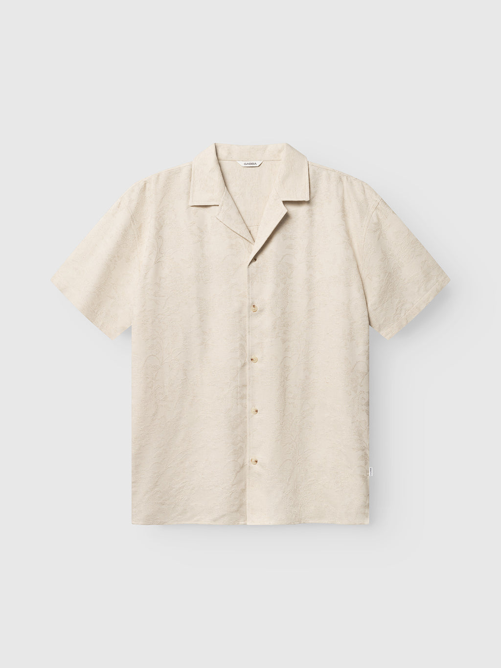 The Gabba GABjens Over Resort Soft SS Shirt in ecru is a short-sleeved, oversized linen shirt with a subtle texture, resort collar, and relaxed fit, shown against a plain light background.