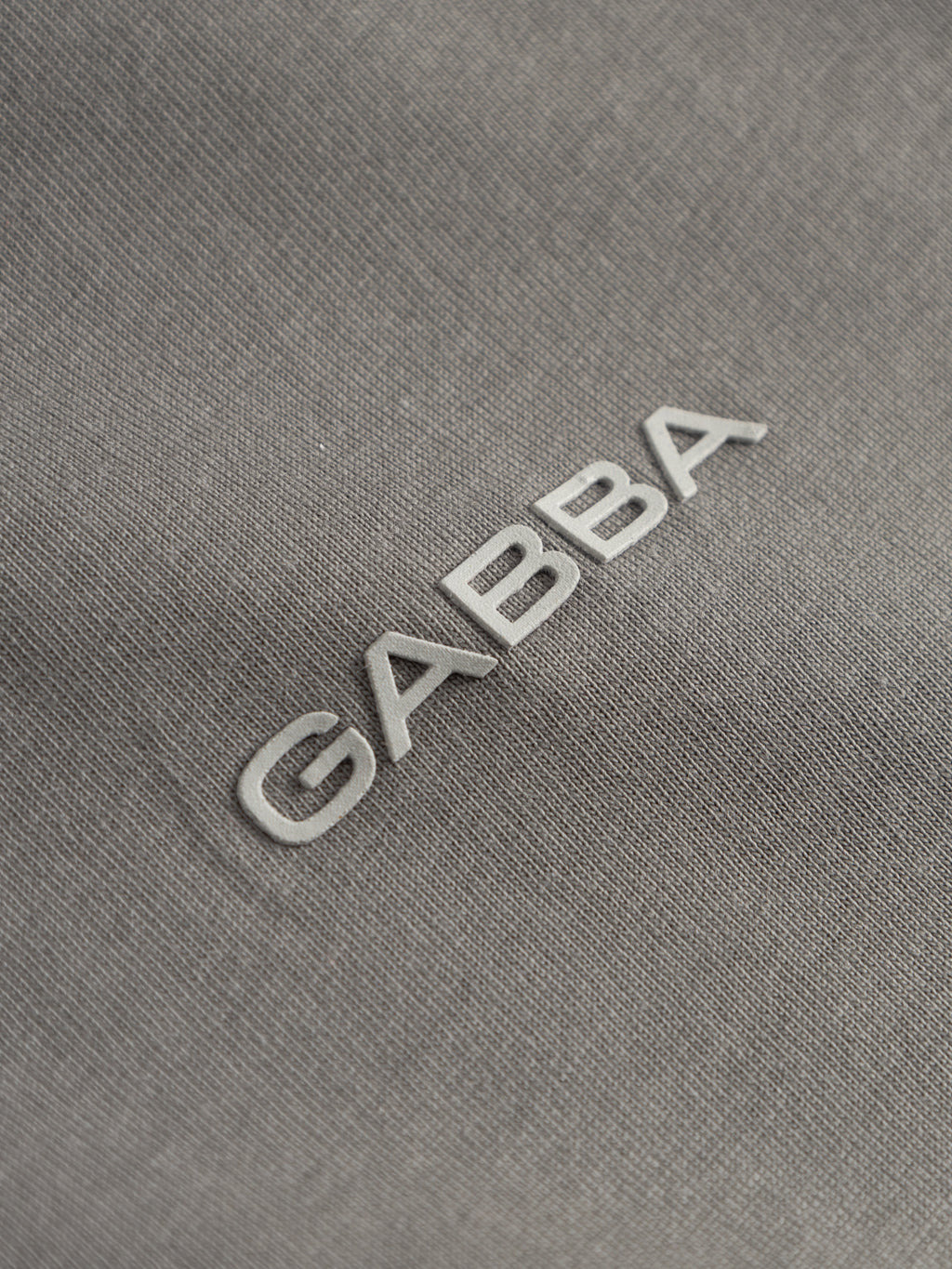 Close-up of the Gabba GABdune Logo GOTS SS T-Shirt in Castor Gray, featuring raised white 