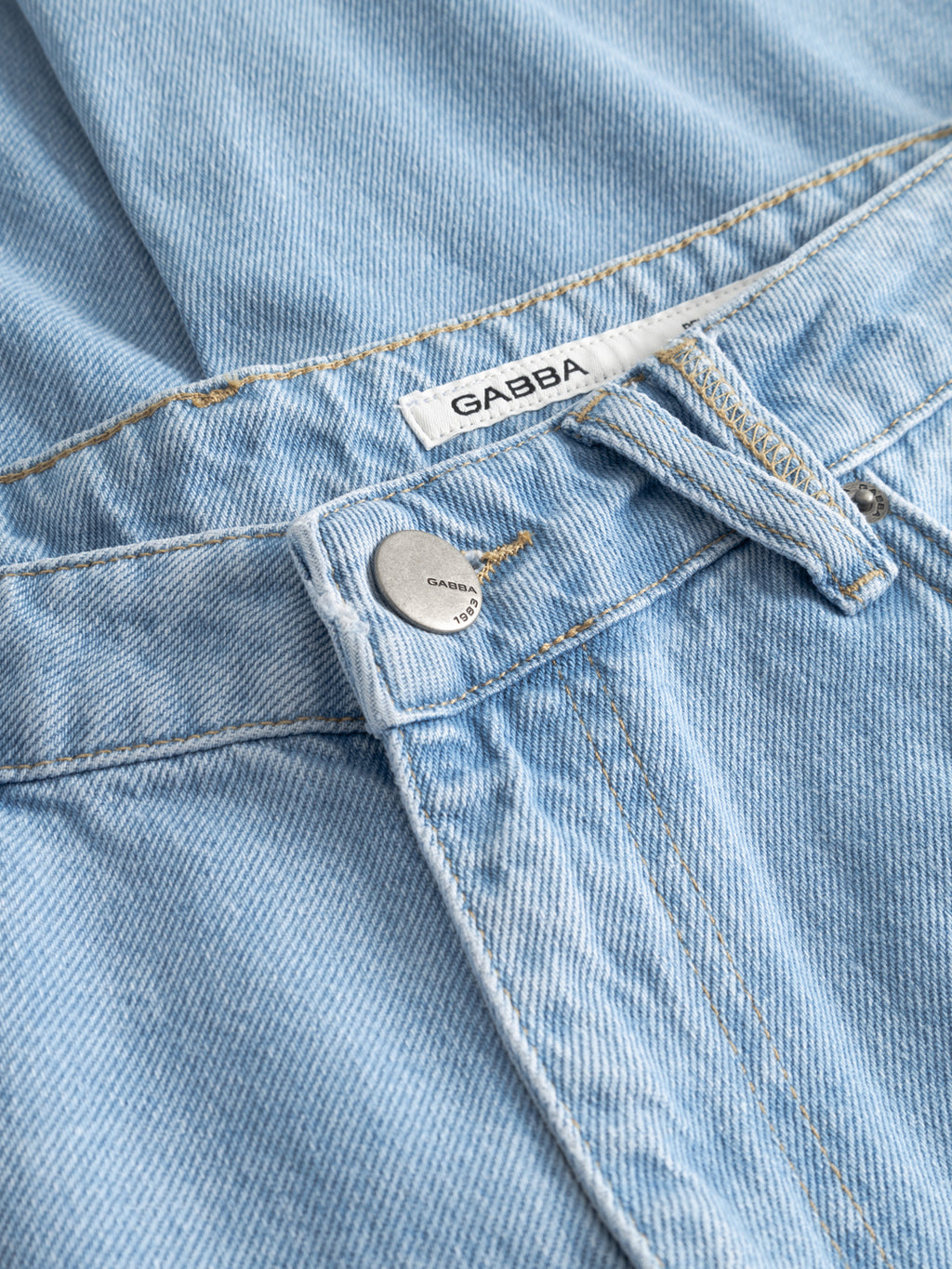 Close-up of Gabba GABmarc 5poc Lig Jeans in light blue denim, highlighting the metal button, belt loops, and classic 5-pocket design with a visible white Gabba label inside the waistband.