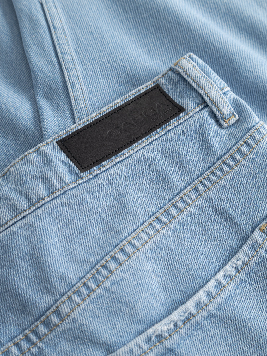 Close-up of Gabba GABmarc 5poc Lig Jeans in light blue denim, featuring a regular fit, classic 5-pocket design, orange stitching, and a black leather patch—an everyday essential.