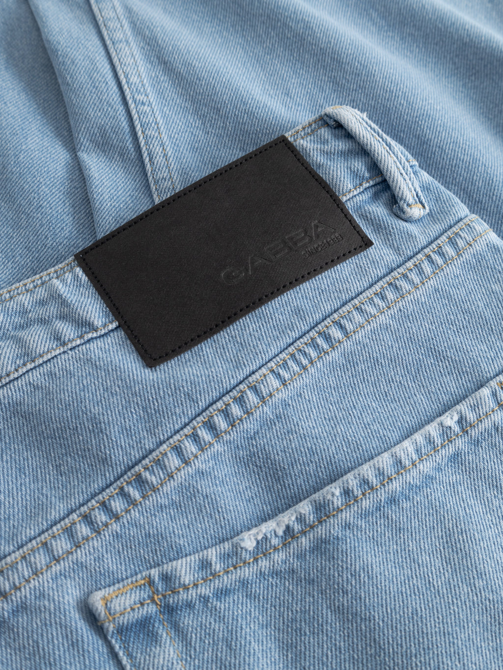 A close-up of Gabba GABmax 5poc Lig Jeans in light blue denim, made from 100% cotton, featuring the back pocket and a black rectangular leather patch with an embossed logo above it.