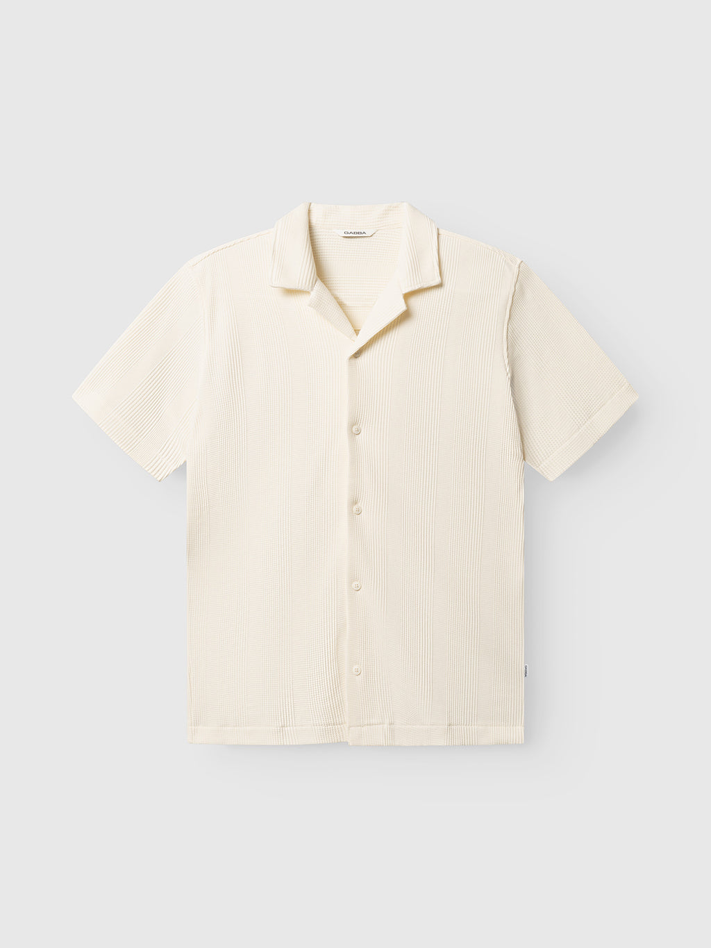 The Gabba GABvalente Wup SS T-Shirt in Bone White features short sleeves, a relaxed fit, resort collar, and waffle-textured fabric. It's shown buttoned flat on a plain light background.