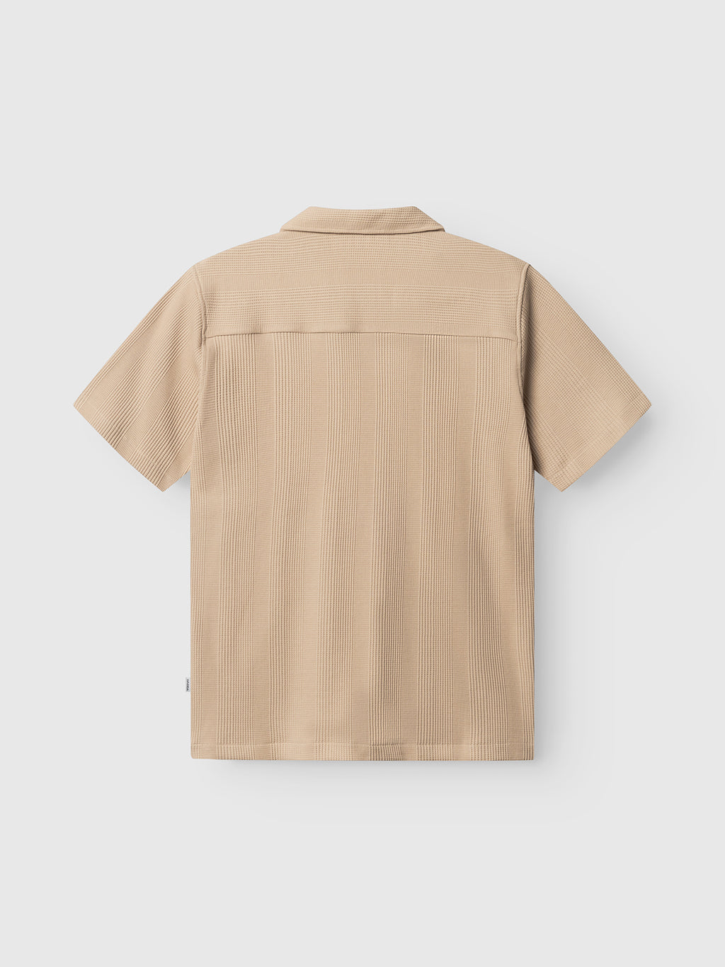 The Gabba GABvalente Wup SS T-Shirt in Humus, shown from the back, features subtle vertical textured stripes, a straight hem, and a relaxed fit with short sleeves. Displayed against a plain white background.