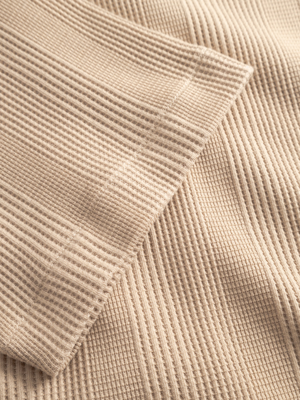 Close-up of the beige ribbed knit fabric on the Gabba GABvalente Wup SS T-Shirt in Humus, showcasing its soft texture and folded edges that highlight the relaxed fit and distinctive waffle-inspired pattern.
