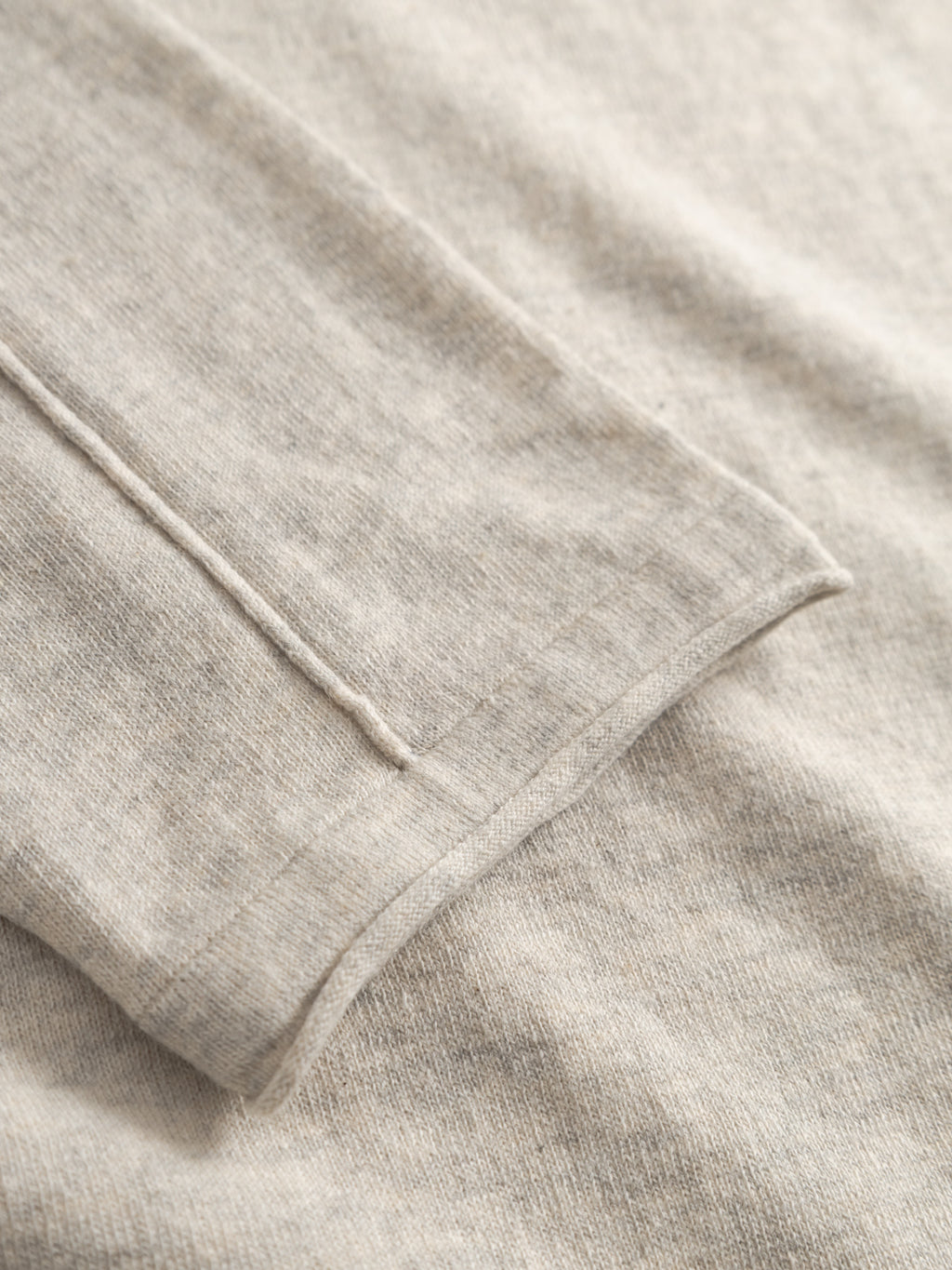 Close-up of the sleeve and body of the Gabba GABlima Cot LS Knit - Sand Mel, a light beige 100% cotton regular fit sweater, showcasing its ribbed texture and seamless detailing.
