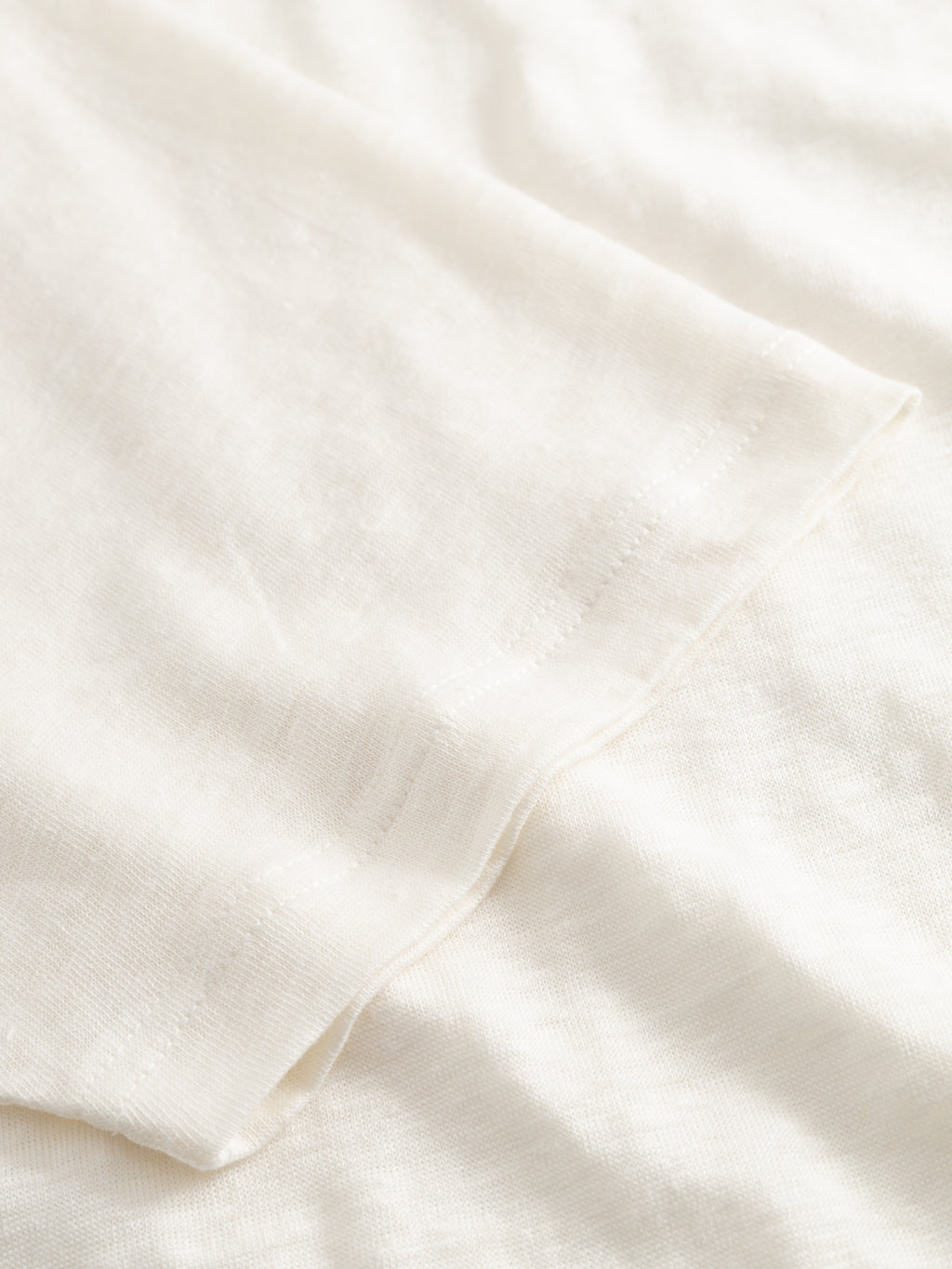 A close-up of Gabba’s GABdune Linen SS T-Shirt in Birch shows its soft, lightweight linen fabric in off-white, featuring a slightly sheer, textured look with gentle folds and a regular fit.