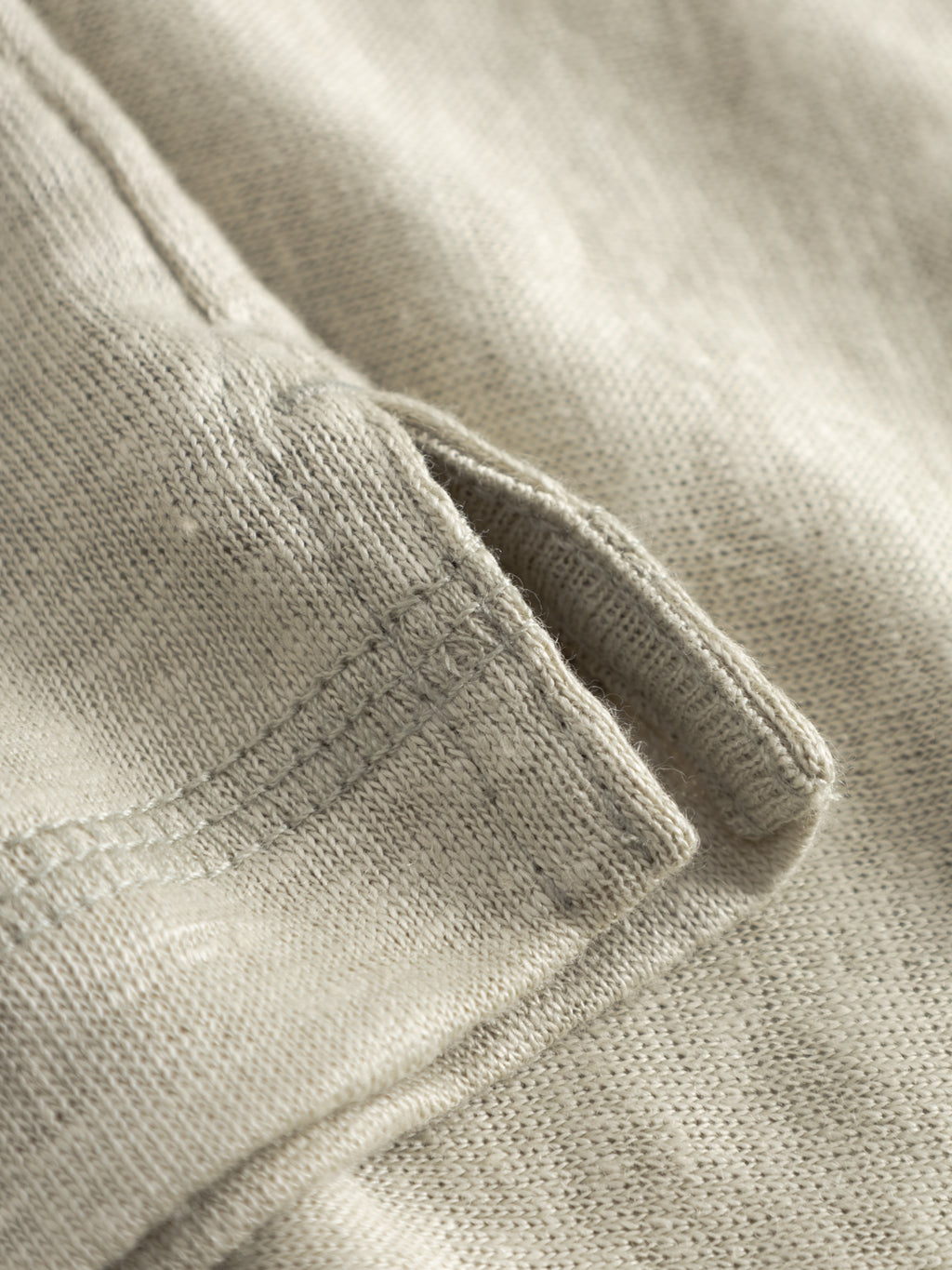 Close-up of the mineral gray GABdune Polo Linen SS T-Shirt by Gabba, featuring a neatly stitched side pocket with visible texture and seam details—showcasing craftsmanship inspired by classic linen polos.