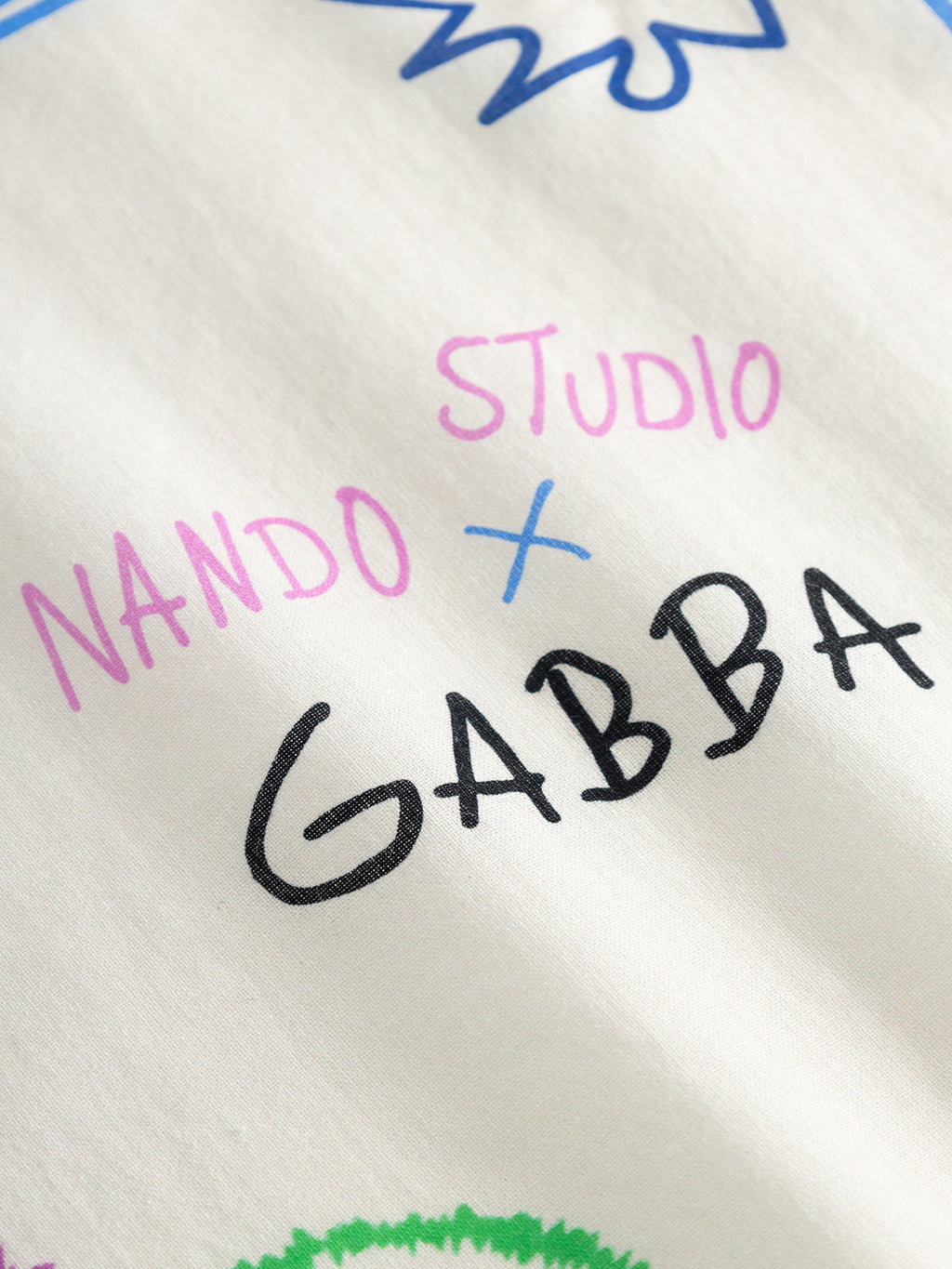 A close-up of the GABnando Bandana - Multi Pattern by Gabba shows soft cotton blend fabric with colorful 