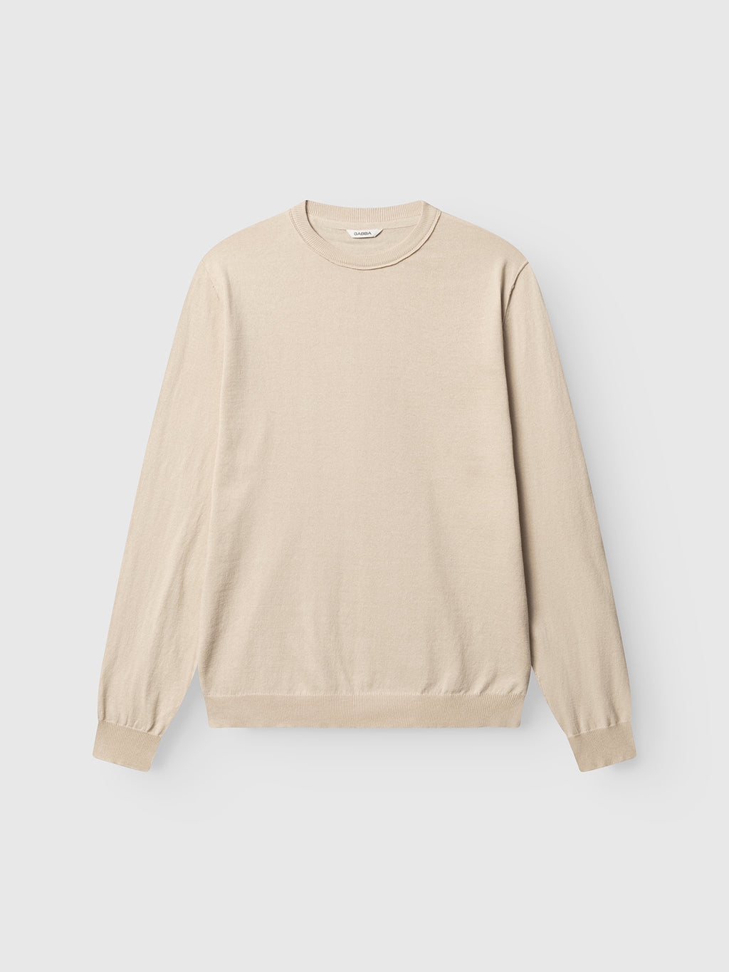 The Gabba GABfumo Spy LS Knit in Sand is a beige, long-sleeve crewneck sweater with a regular fit, ribbed cuffs and hem, and a minimalist design, shown laid flat on a plain white background.