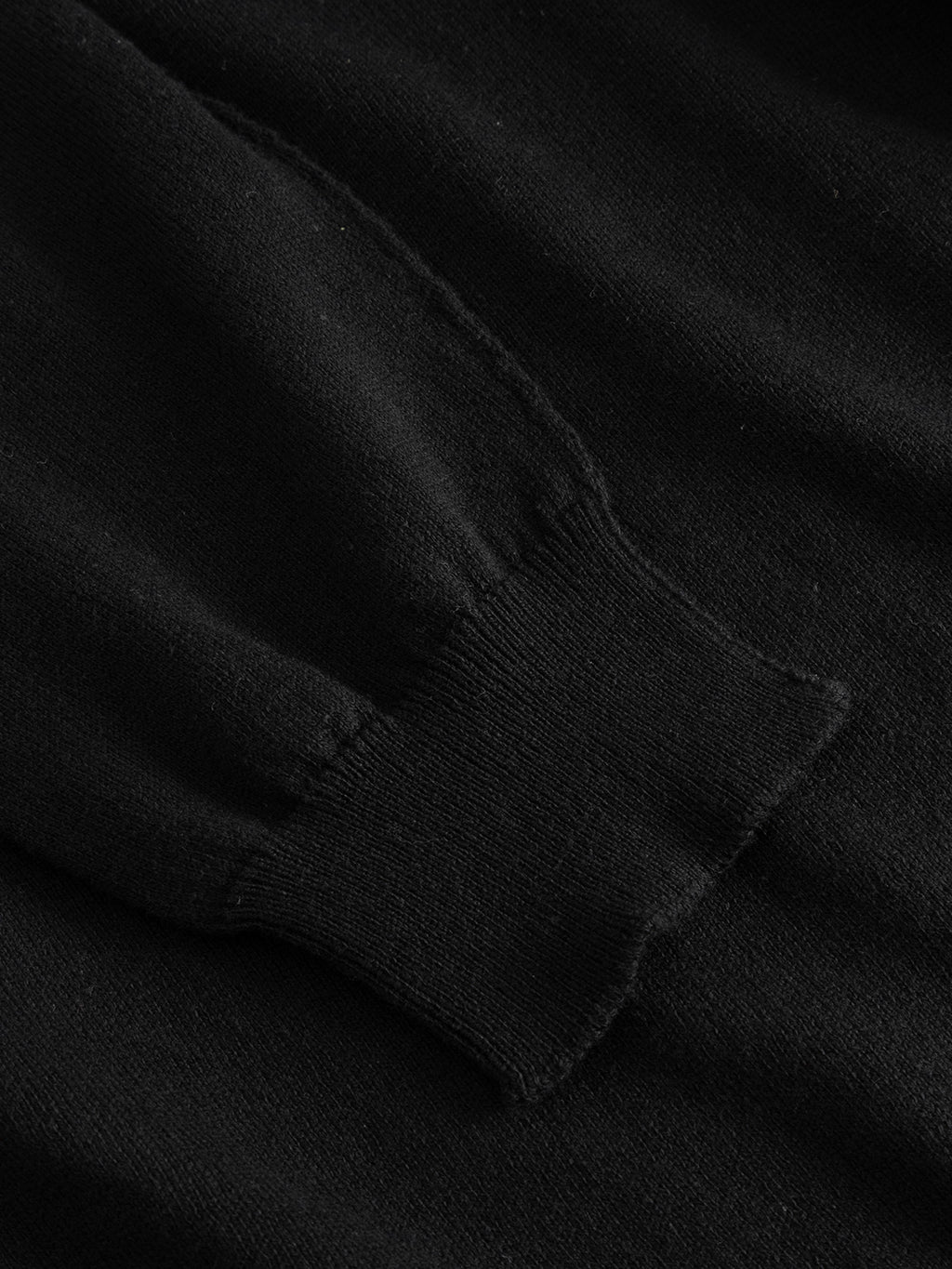 Close-up of the Gabba GABfumo Spy LS Knit - Black, highlighting the flat-knit 100% cotton fabric with visible cuff, seam, and precise stitching against a matching dark background.
