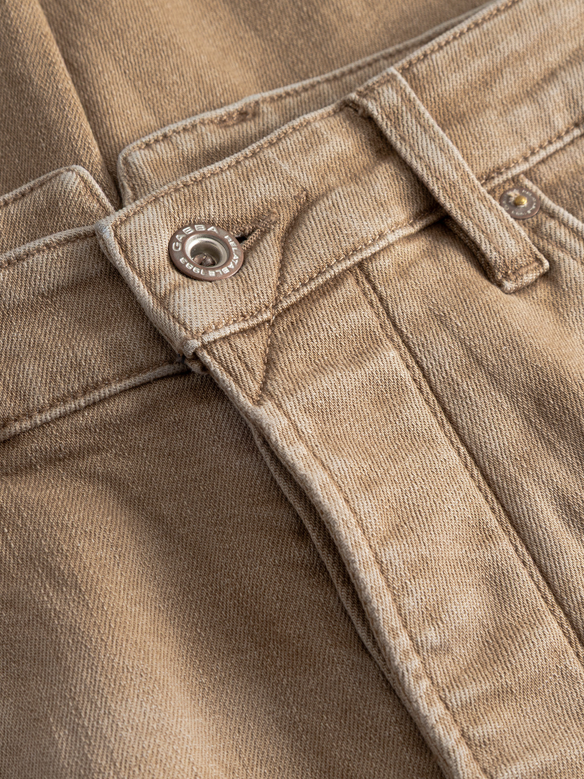 Close-up of Gabba GABalex Earth - Sand relaxed-fit jeans, highlighting the waistband, button, belt loop, and visible stitching details on light brown sand denim.