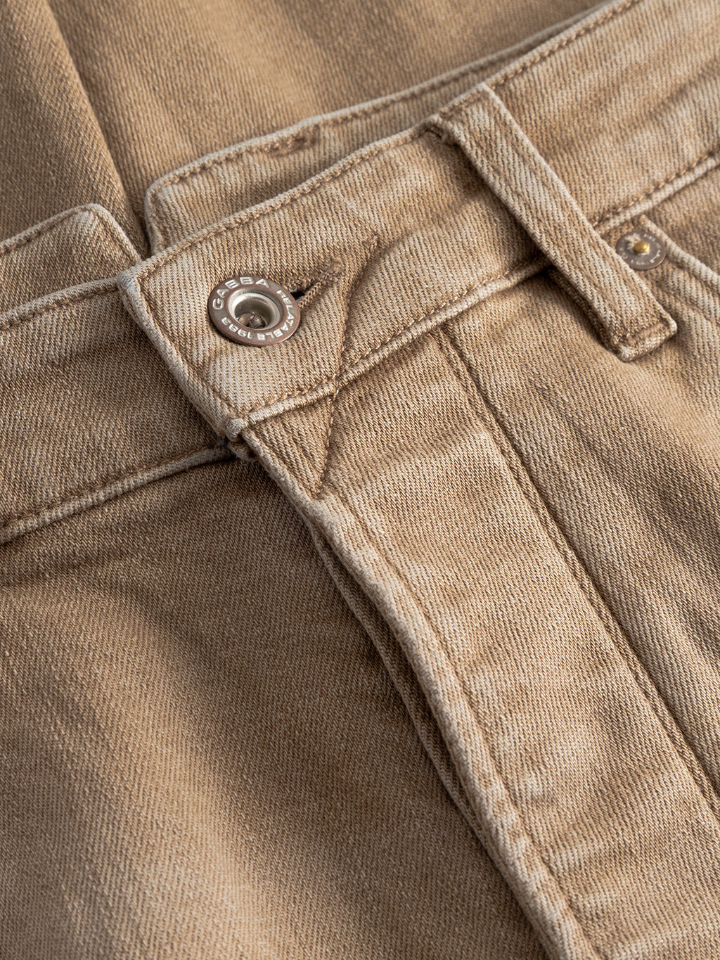 Close-up of Gabba GABalex Earth - Sand relaxed-fit jeans, highlighting the waistband, button, belt loop, and visible stitching details on light brown sand denim.