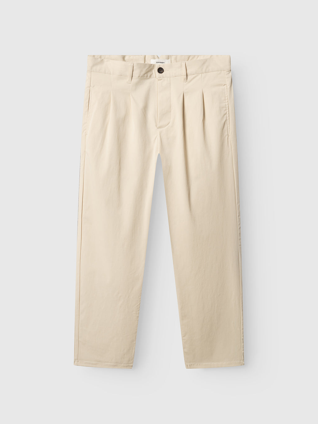 The GABfirenze Bolu Cropped TENCEL™ Pant in Birch by Gabba features pleats, a button and zipper closure, belt loops, and straight legs. Shown laid flat on a white background.