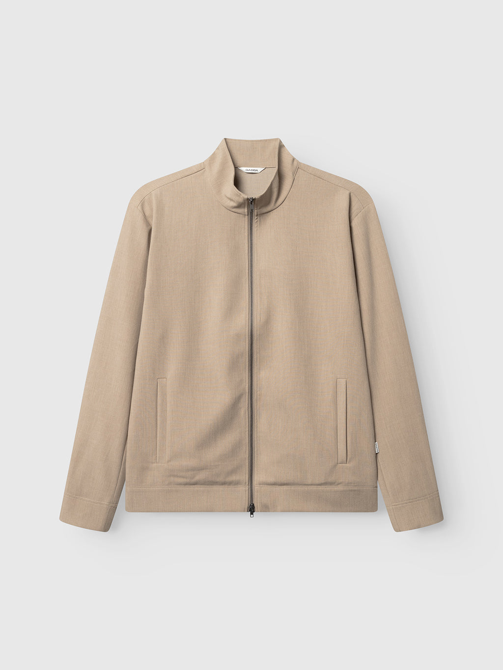 The Gabba GABnik Phin GRS - Sand Plaza is a beige, long-sleeved zip-through jacket made from recycled polyester, with a stand collar and two front pockets, shown laid flat on a white background.