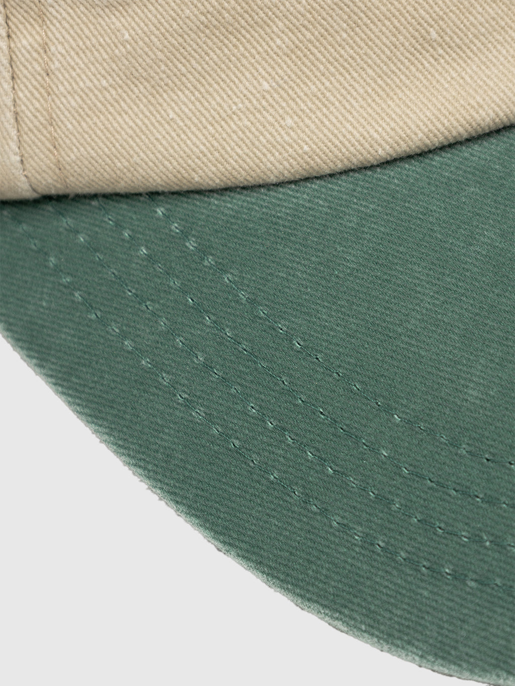 Close-up of the Gabba GABnbh Club Cap - Green, featuring a beige crown and green brim in soft fabric that showcases detailed stitching and texture.
