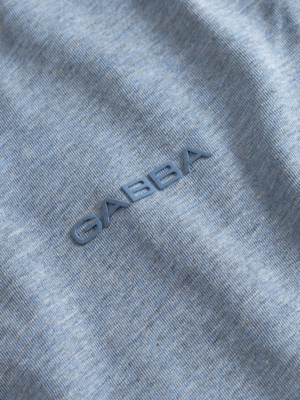 Close-up of the Gabba GABdune Melange New SS T-Shirt in Blue Melange, featuring a textured fabric and an embroidered chest logo in matching blue, showcasing the soft hand feel typical of melange jersey.