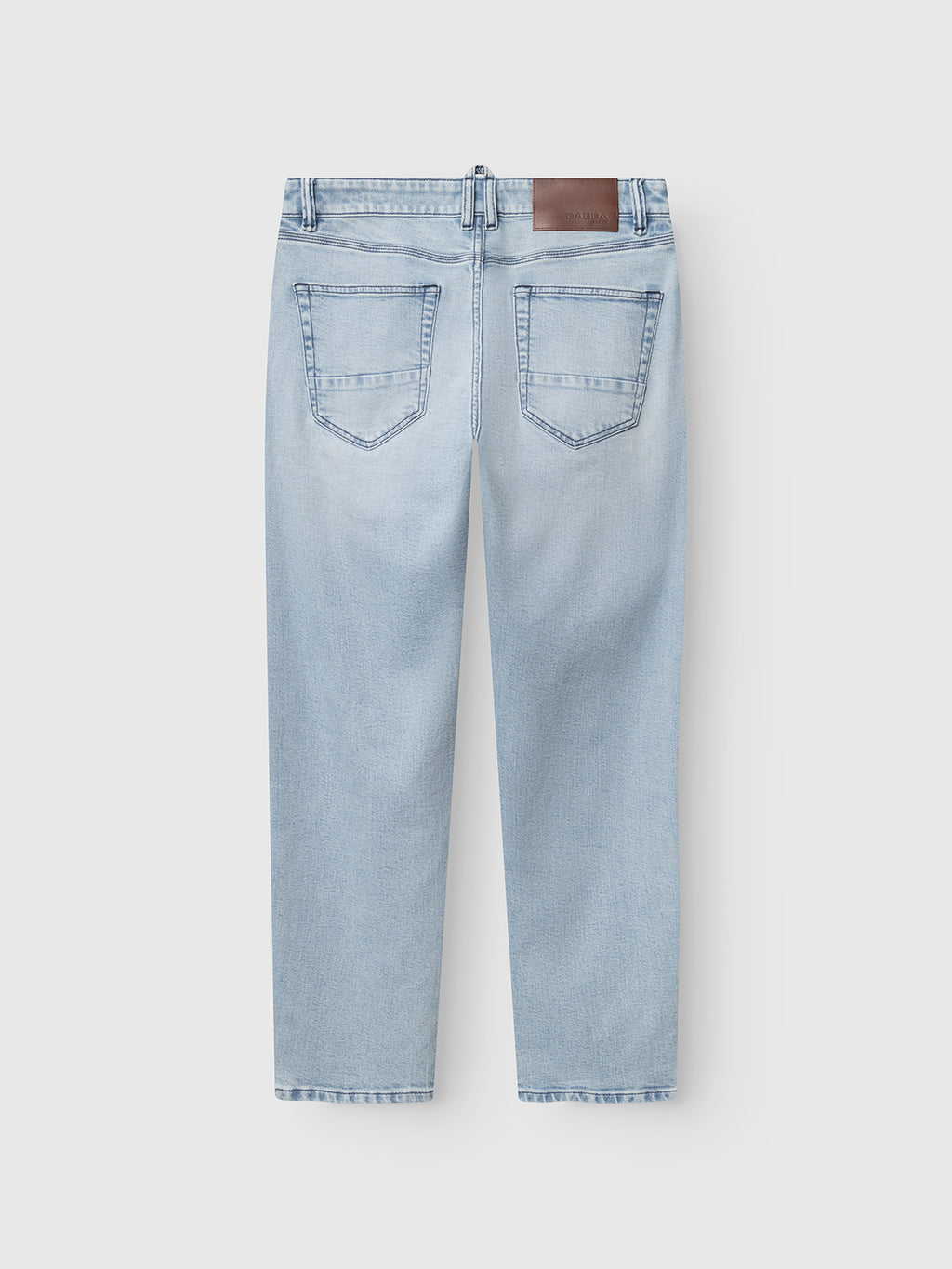 The Gabba GABcarl Swif Jeans in light blue denim are relaxed tapered jeans with two back pockets, belt loops, and a brown leather patch on the waistband. Crafted from comfort stretch denim and shown flat on a white background.