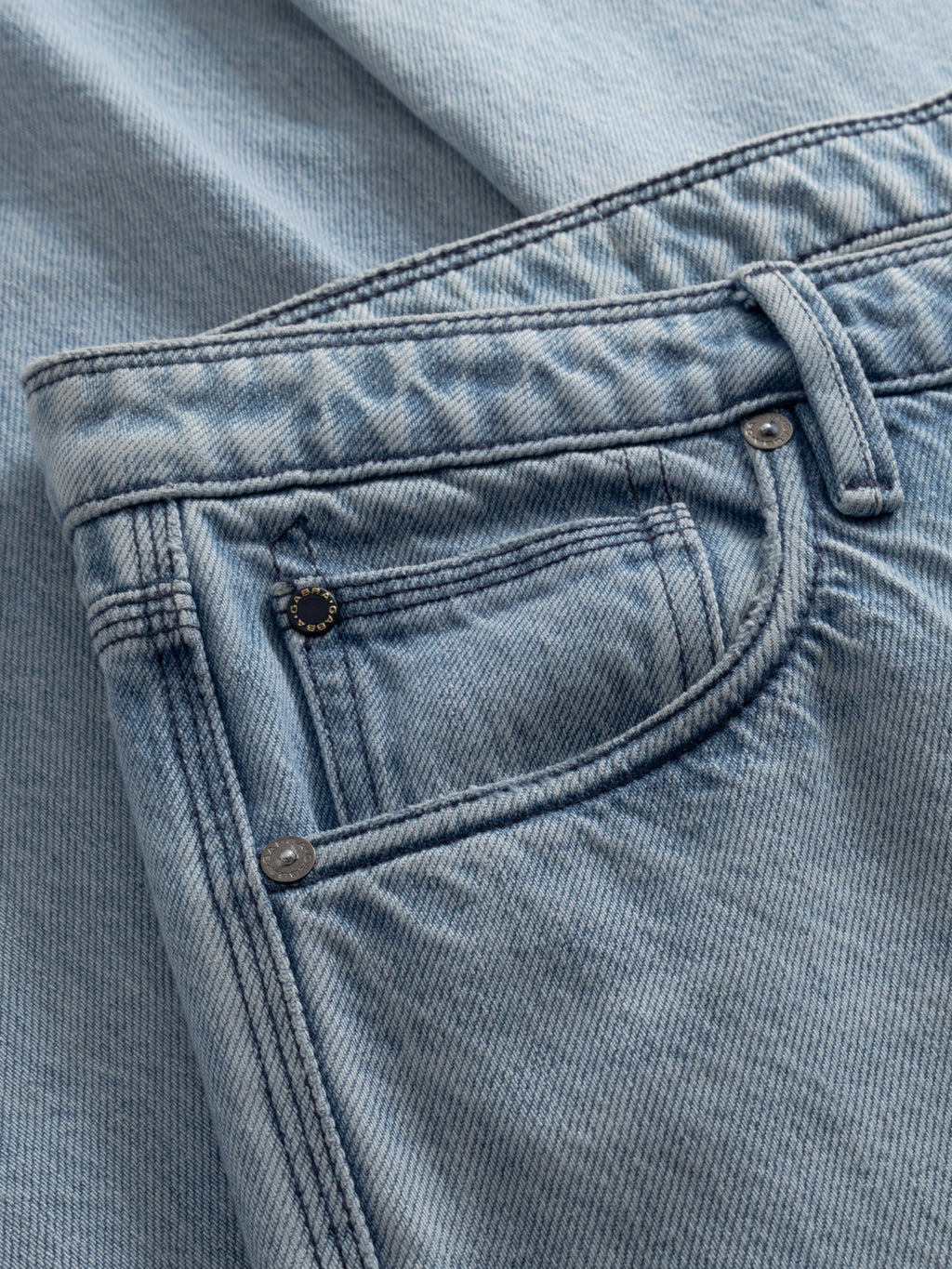 A close-up of Gabba’s GABmax Elvis Jeans in light blue denim, highlighting the front pocket, coin pocket, belt loops, stitching details, fabric texture, and classic rivets.