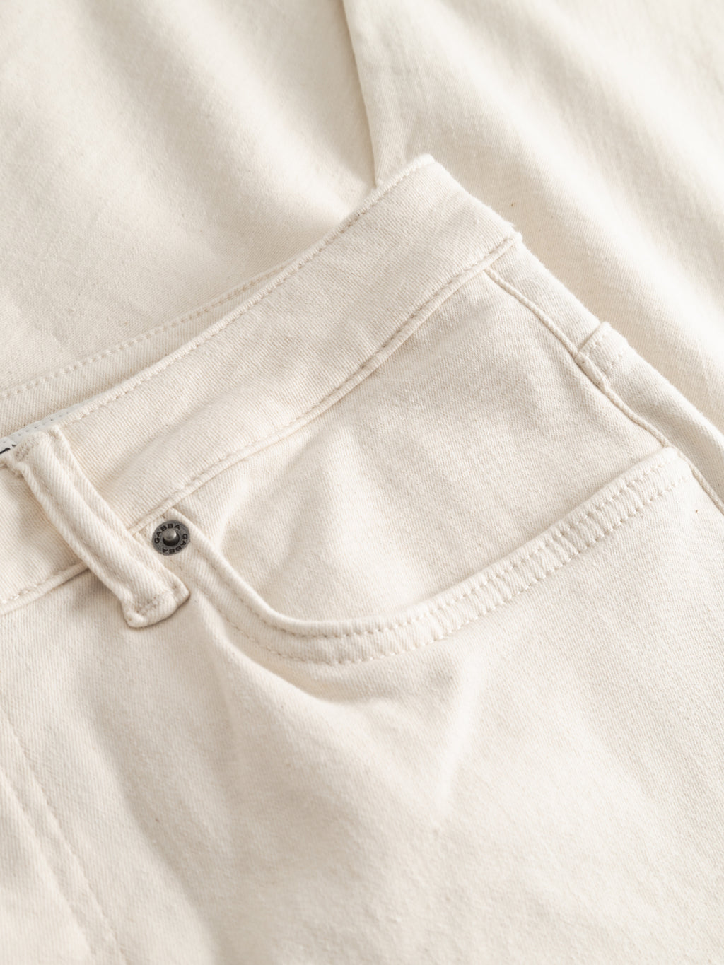 Close-up of the front pocket and waistband of Gabba GABjones Heski Jeans in ecru, showcasing the superstretch fabric texture and fine stitching.