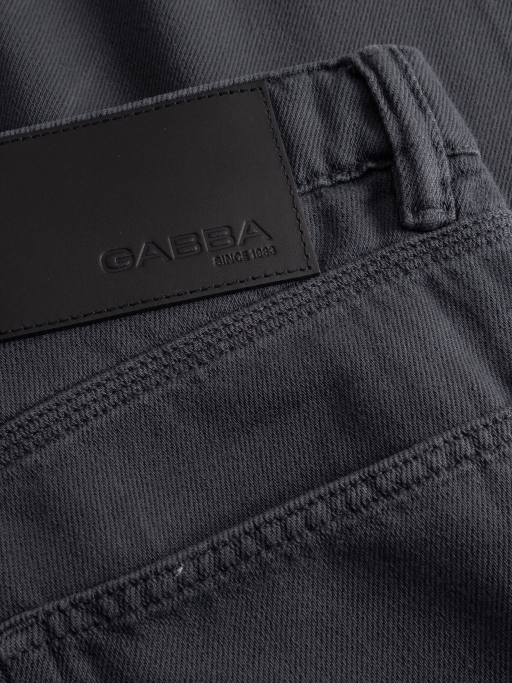 Close-up of the waistband and back pocket of GABcarl Blancel TENCEL™ Jeans - Black by Gabba, crafted from a soft TENCEL cotton blend. The black leather patch is embossed with Gabba and SINCE 1983.